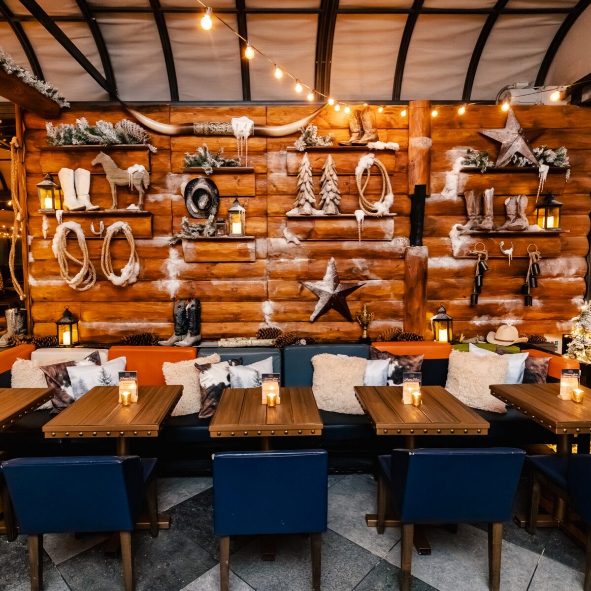 Western-themed decor wall with bighorn antlers, cowboy boots, and Western artifacts