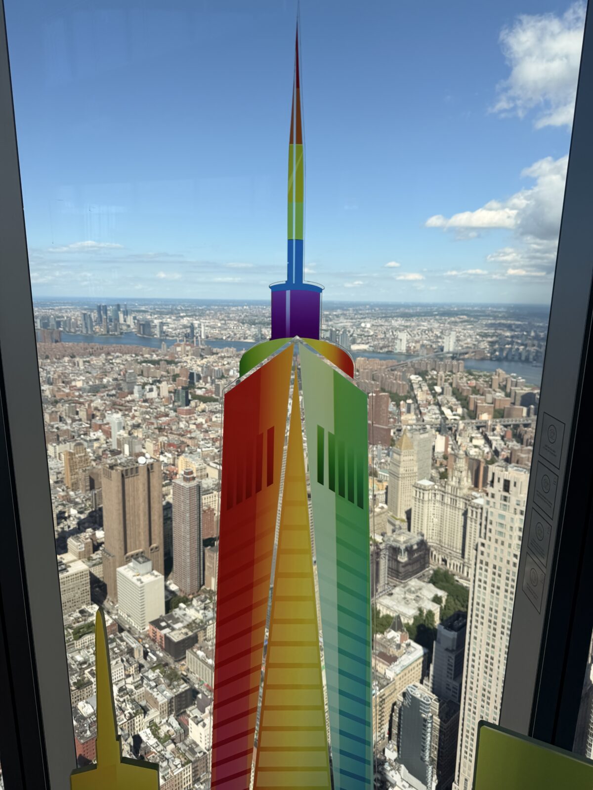 One Love rainbow One World Trade Center sculpture lit at dusk on the observation deck